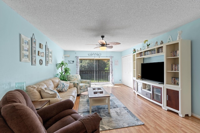 living room featuring ceiling fan, a textured ceiling, and light hardwood / wood-style flooring