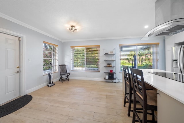 dining area featuring crown molding, a healthy amount of sunlight, and light hardwood / wood-style floors