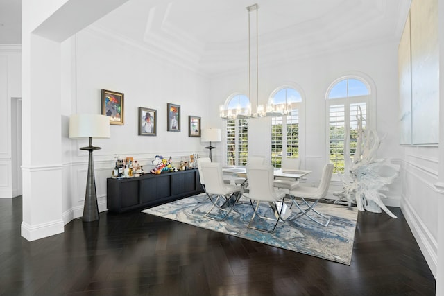 dining space featuring dark parquet flooring, crown molding, and a notable chandelier