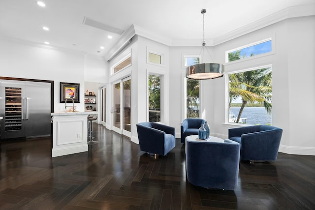 interior space with dark parquet flooring, a high ceiling, and ornamental molding