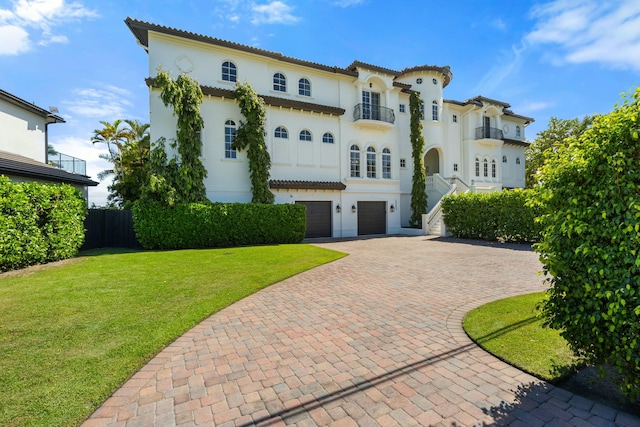 mediterranean / spanish home featuring a front lawn and a garage