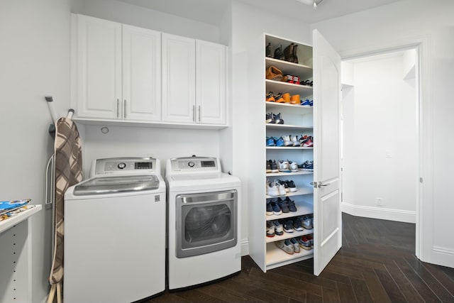 laundry room featuring dark parquet floors, cabinets, and washing machine and clothes dryer