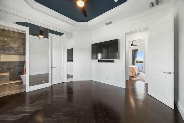 spare room with a raised ceiling, ceiling fan, and ornamental molding