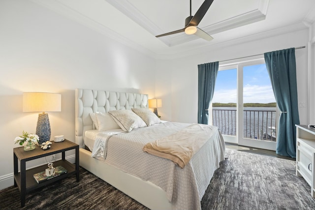 bedroom featuring dark wood-type flooring, a water view, ceiling fan, access to exterior, and ornamental molding