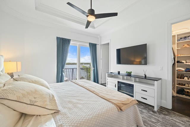 bedroom with a walk in closet, access to outside, ceiling fan, dark hardwood / wood-style floors, and a closet