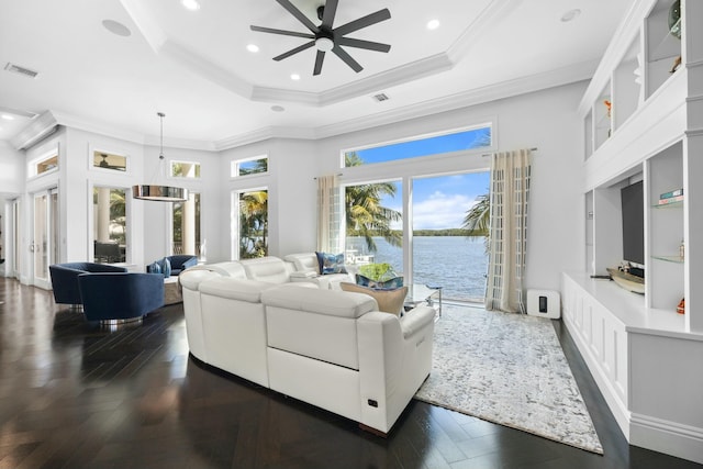 living room with a water view, a raised ceiling, ceiling fan, and ornamental molding