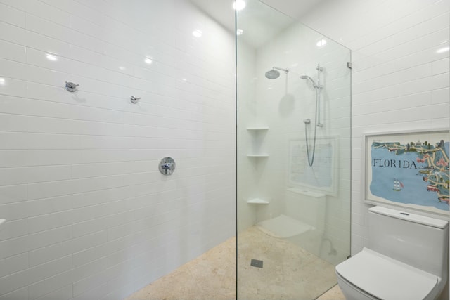 bathroom featuring a tile shower and toilet