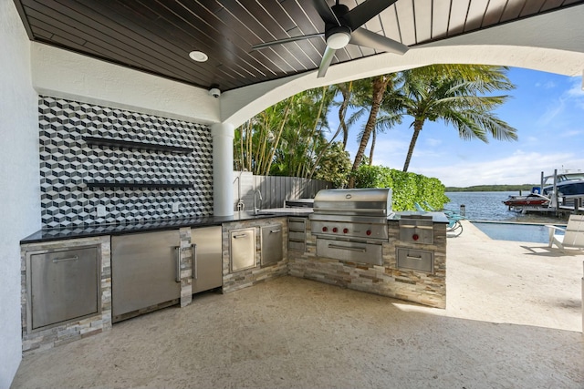 view of patio with ceiling fan, sink, grilling area, area for grilling, and a water view