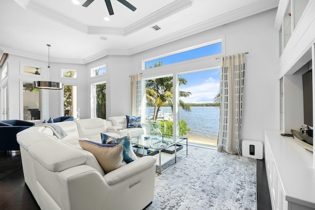 living room with crown molding, dark hardwood / wood-style flooring, a water view, and a healthy amount of sunlight