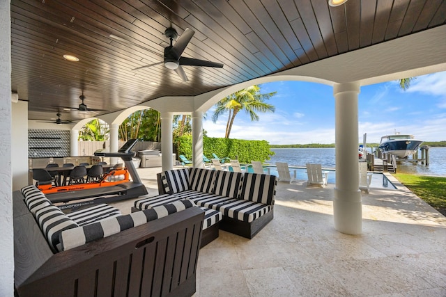 view of patio / terrace featuring an outdoor kitchen, ceiling fan, a water view, and an outdoor hangout area