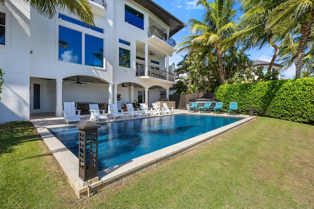 view of swimming pool featuring a lawn, a patio area, and ceiling fan