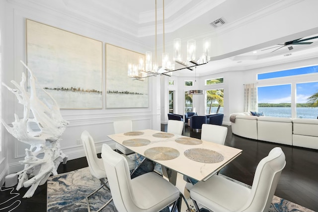 dining room featuring wood-type flooring, a water view, ceiling fan, and crown molding