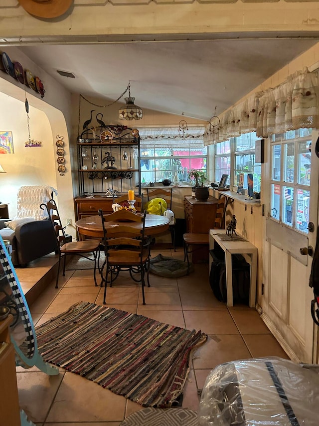 dining area featuring lofted ceiling and light tile patterned floors