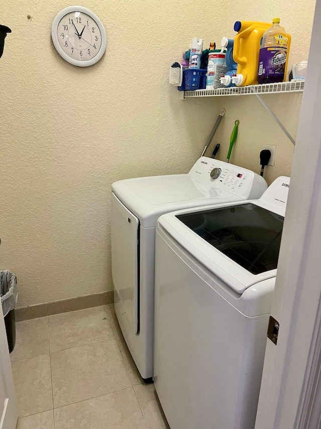 washroom with washer and clothes dryer and light tile patterned floors