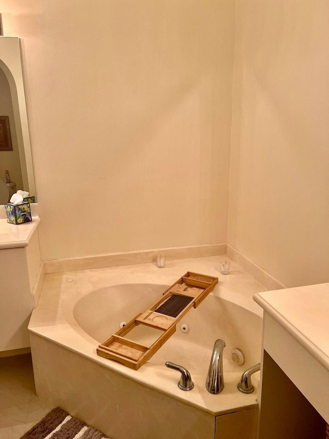 bathroom with tile patterned floors, a tub, and vanity