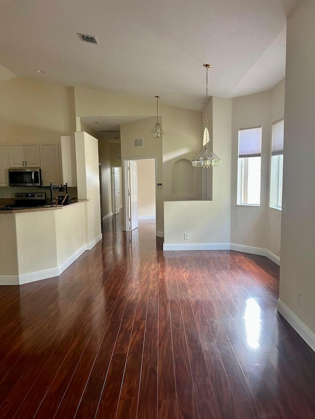 empty room with dark hardwood / wood-style flooring and lofted ceiling