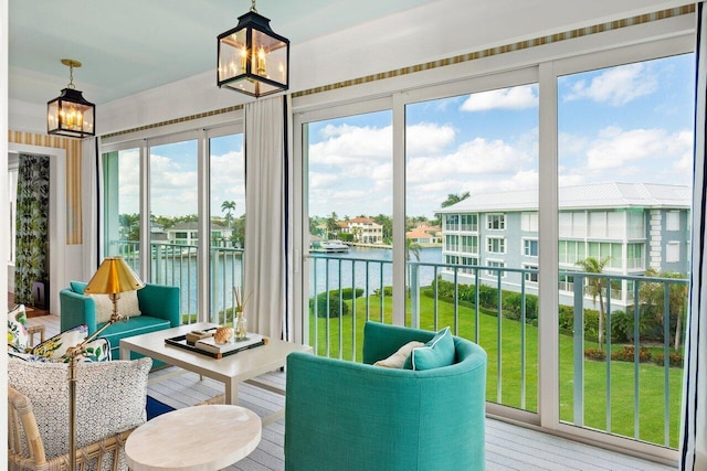 sunroom / solarium featuring a chandelier and a water view