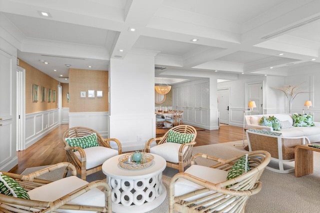 living room featuring beam ceiling, crown molding, light hardwood / wood-style flooring, and coffered ceiling