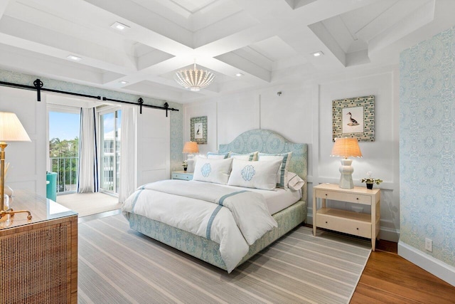 bedroom featuring access to outside, coffered ceiling, hardwood / wood-style flooring, a barn door, and beamed ceiling