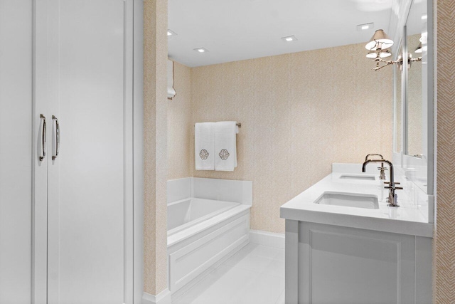 bathroom with tile patterned flooring, vanity, a tub to relax in, and an inviting chandelier