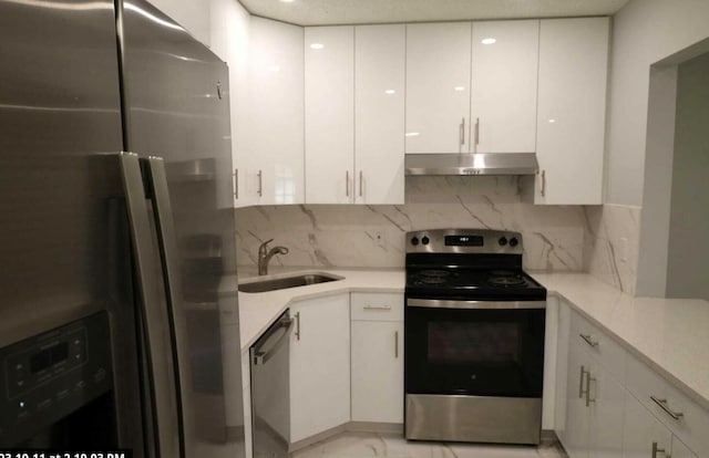 kitchen with white cabinets, decorative backsplash, sink, and stainless steel appliances