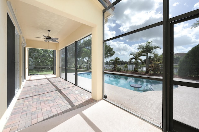 unfurnished sunroom with ceiling fan