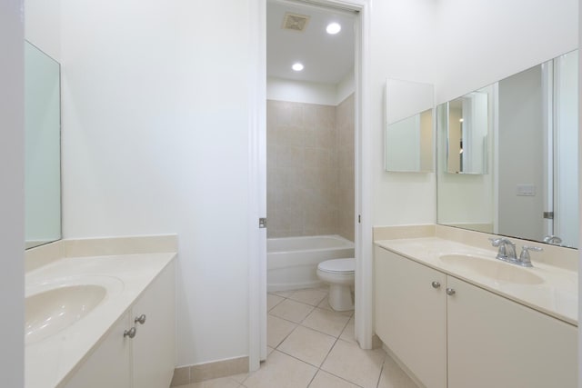 full bathroom with tile patterned floors, tiled shower / bath, vanity, and toilet