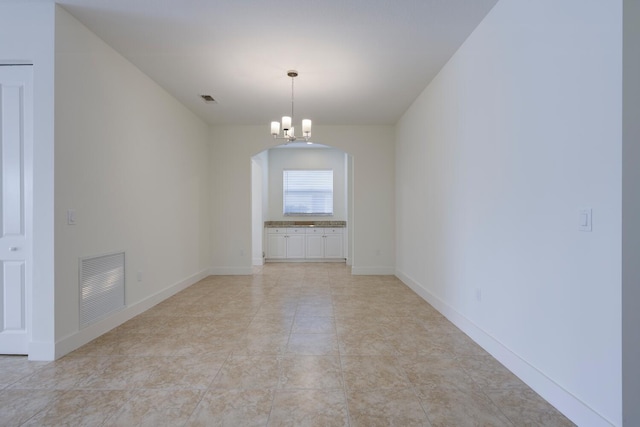 empty room featuring a chandelier