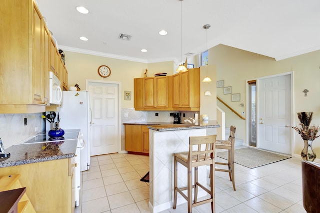 kitchen with light tile patterned floors, dark stone counters, and decorative light fixtures