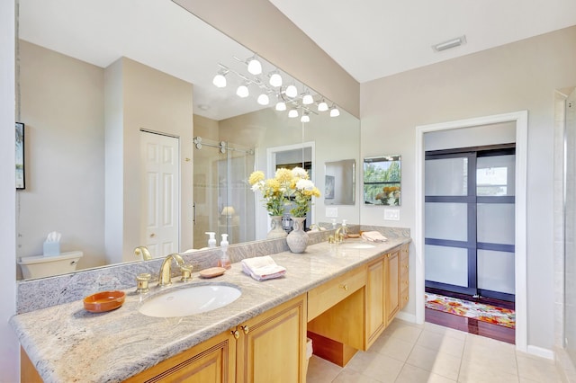 bathroom with toilet, tile patterned flooring, vanity, and walk in shower