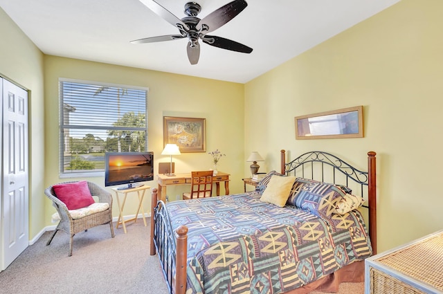 bedroom with ceiling fan, light colored carpet, and a closet