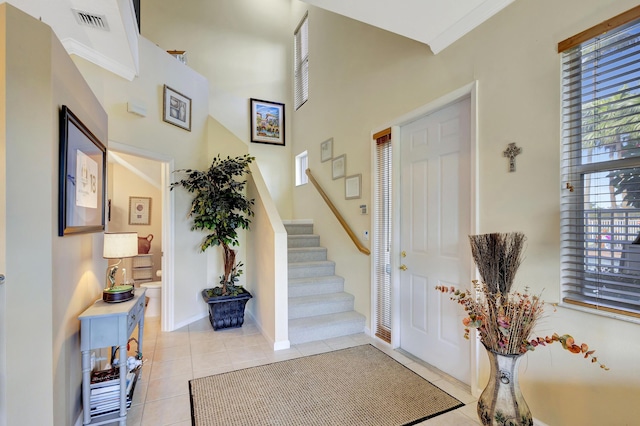 foyer entrance featuring crown molding and light tile patterned flooring