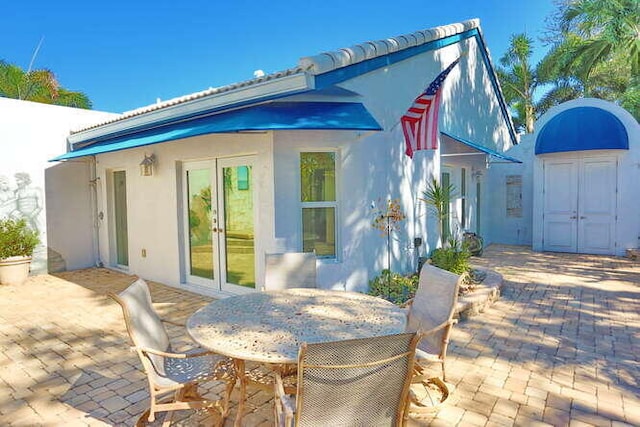 rear view of property featuring french doors and a patio area