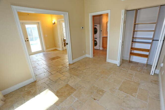 unfurnished bedroom with stacked washer and dryer and a closet