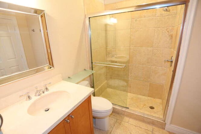 bathroom with vanity, an enclosed shower, and toilet