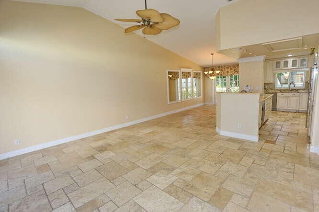 kitchen featuring ceiling fan with notable chandelier, sink, and high vaulted ceiling