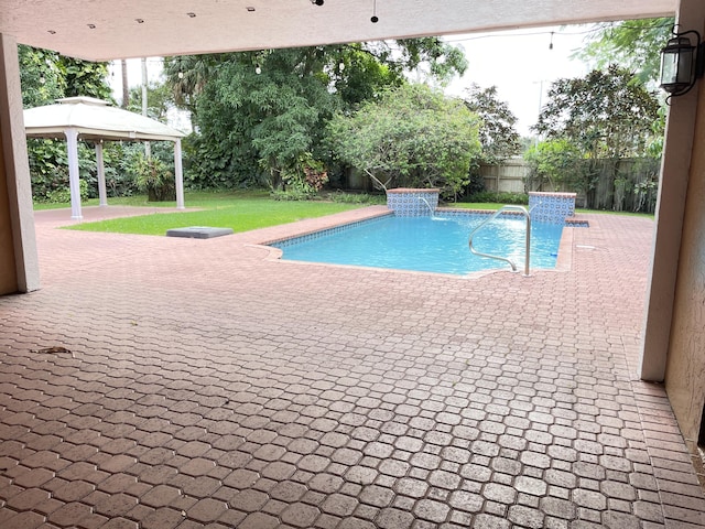 view of pool featuring a gazebo, a patio area, pool water feature, and a lawn