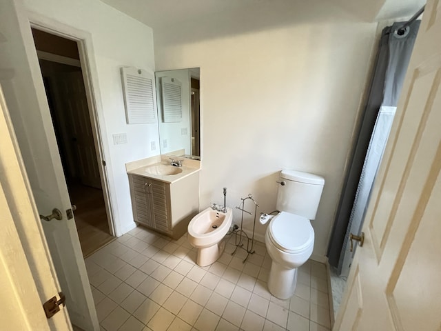 bathroom with tile patterned flooring, vanity, toilet, and a bidet