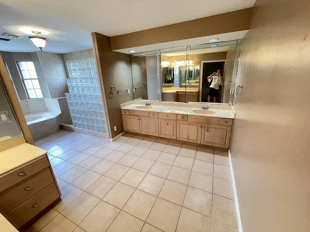 bathroom featuring tile patterned floors, tiled bath, and vanity