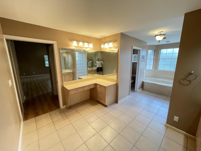 bathroom featuring tile patterned floors, vanity, toilet, and tiled tub