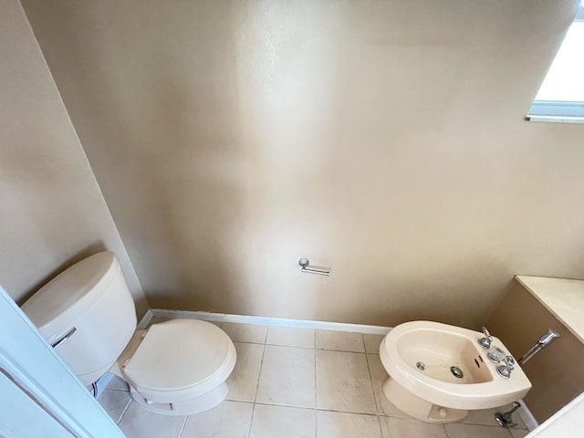 bathroom with tile patterned flooring, toilet, and a bidet