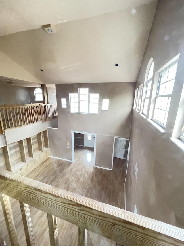 unfurnished living room with hardwood / wood-style floors, high vaulted ceiling, and a wealth of natural light