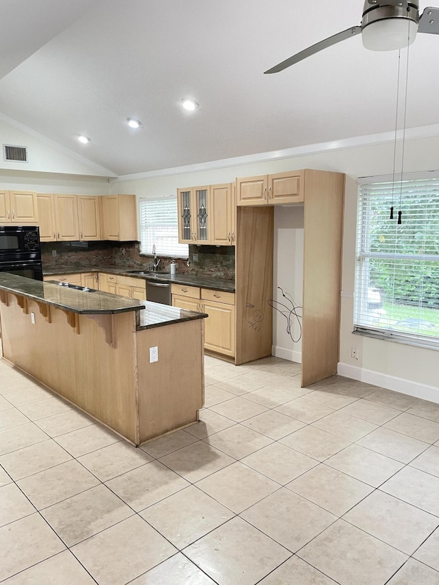 kitchen with a breakfast bar, lofted ceiling, ceiling fan, tasteful backsplash, and black microwave