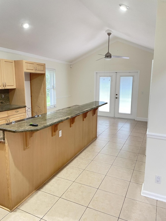 kitchen featuring a breakfast bar, plenty of natural light, and vaulted ceiling