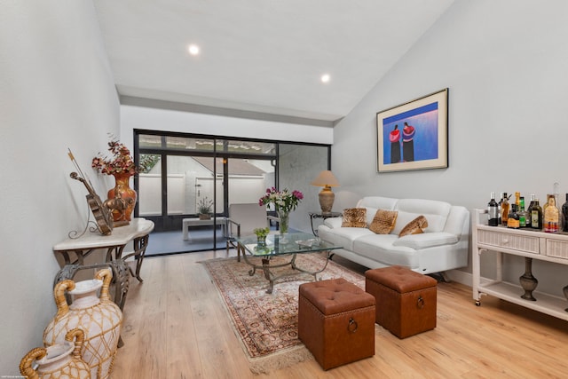 living room with vaulted ceiling and light hardwood / wood-style flooring