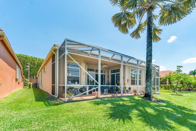 back of house with a lawn, glass enclosure, and central AC