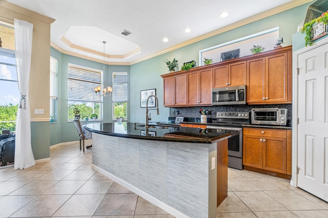 kitchen with backsplash, an island with sink, a chandelier, light tile patterned floors, and appliances with stainless steel finishes