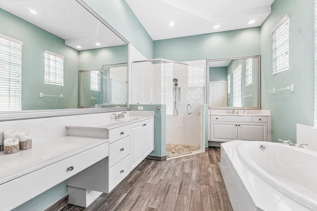 bathroom featuring hardwood / wood-style floors, vanity, and shower with separate bathtub