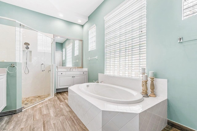 bathroom featuring hardwood / wood-style flooring, vanity, a healthy amount of sunlight, and separate shower and tub