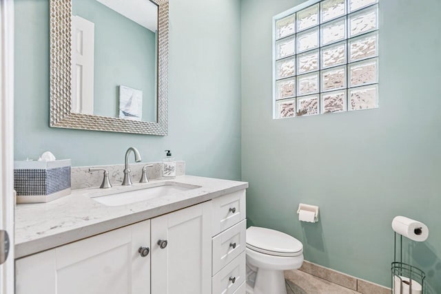 bathroom featuring tile patterned flooring, vanity, and toilet